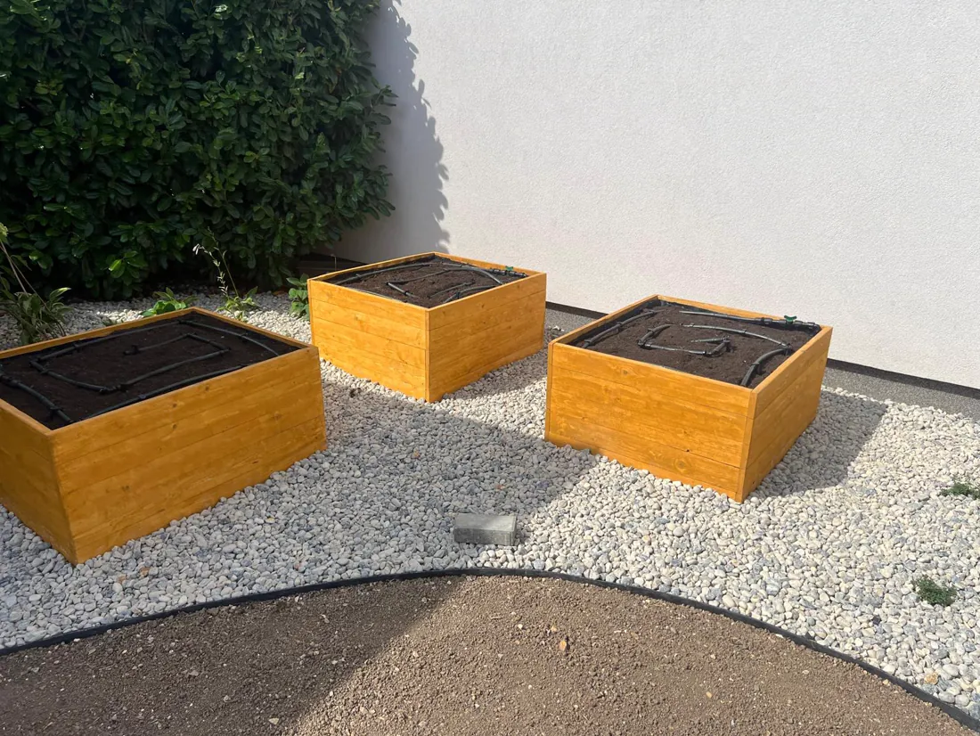Dřevěné boxy s odklápěcím víkem na štěrkovém záhonu